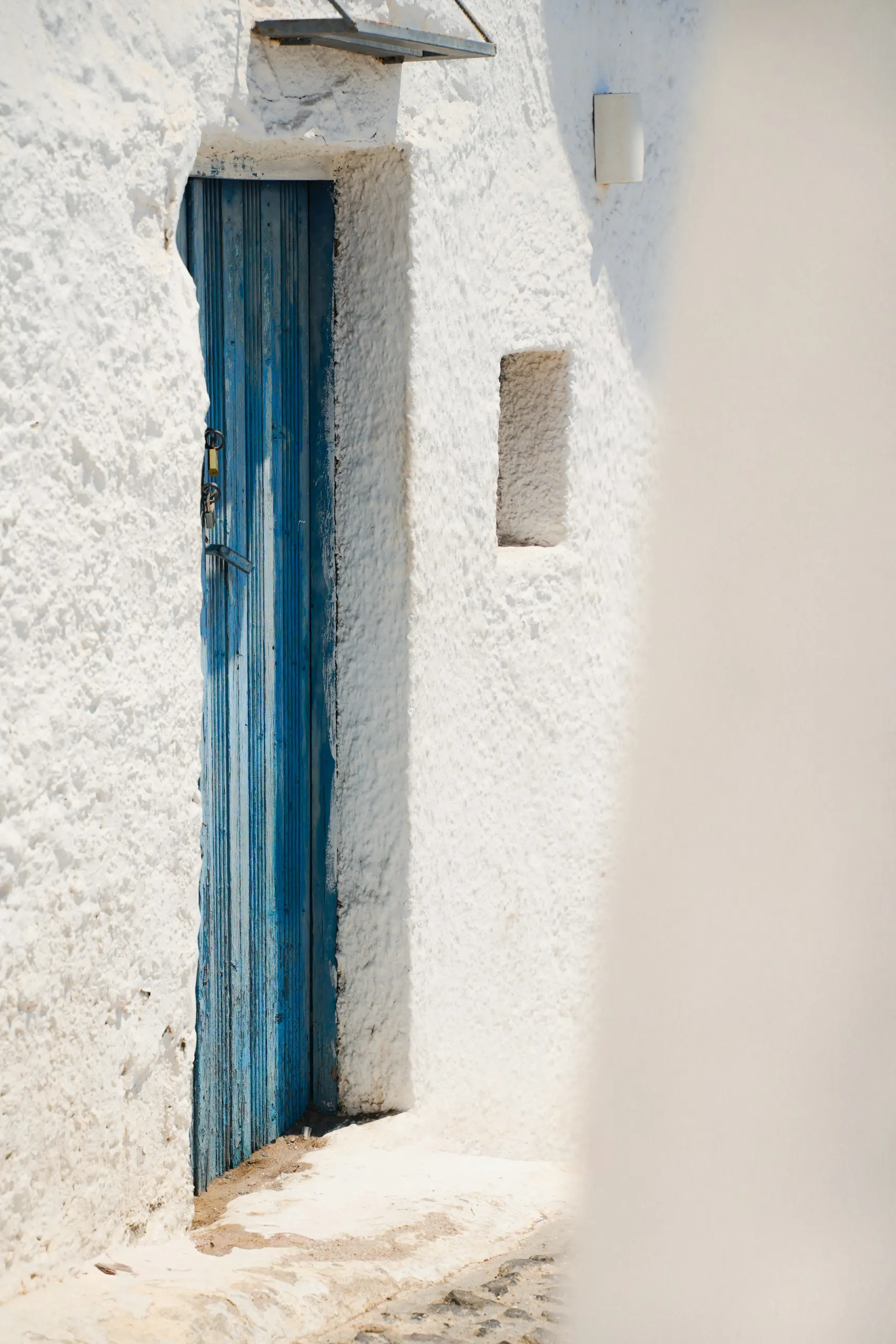 Blue wooden door set in a whitewashed wall