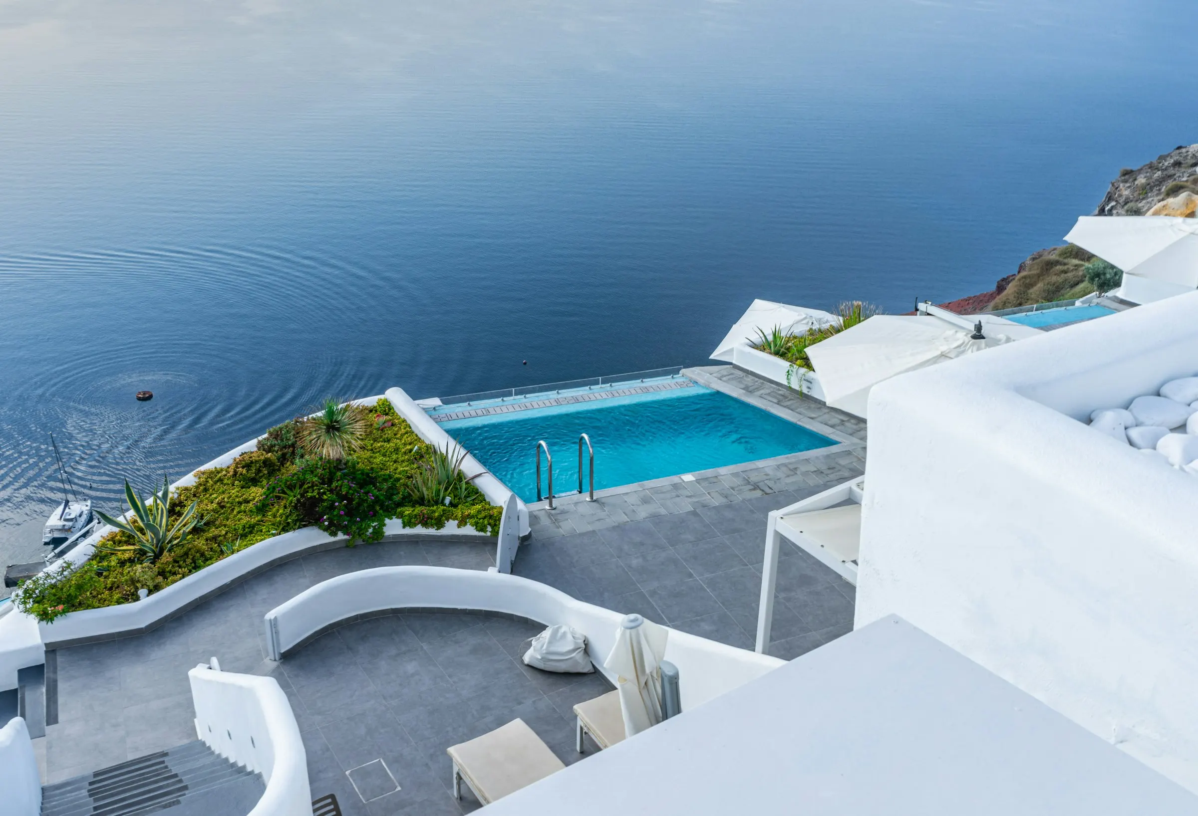 Infinity pool on a whitewashed terrace above the Aegean, Santorini caldera
