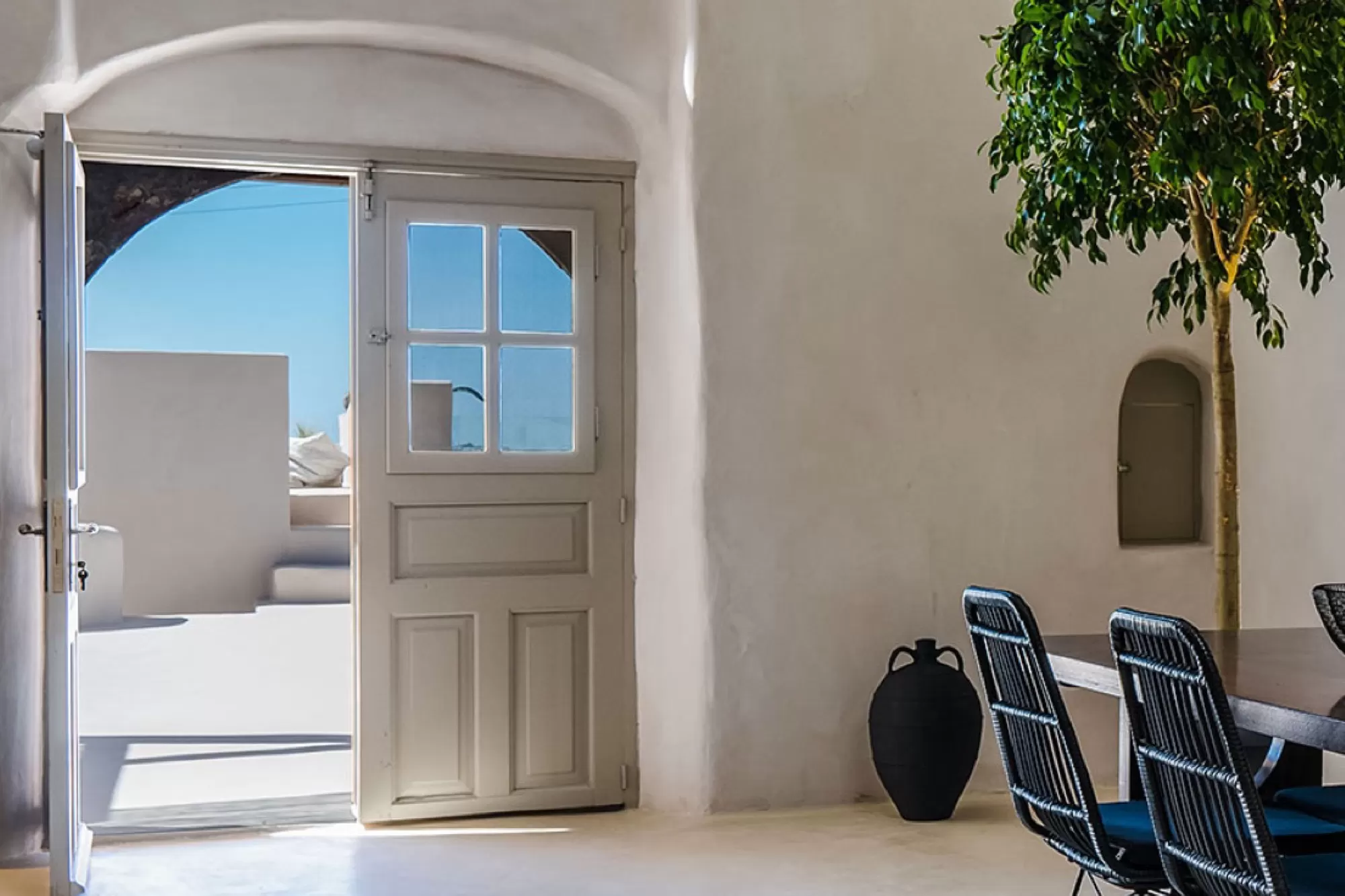Arched doorway and olive tree inside a cave suite at Phaos 1870