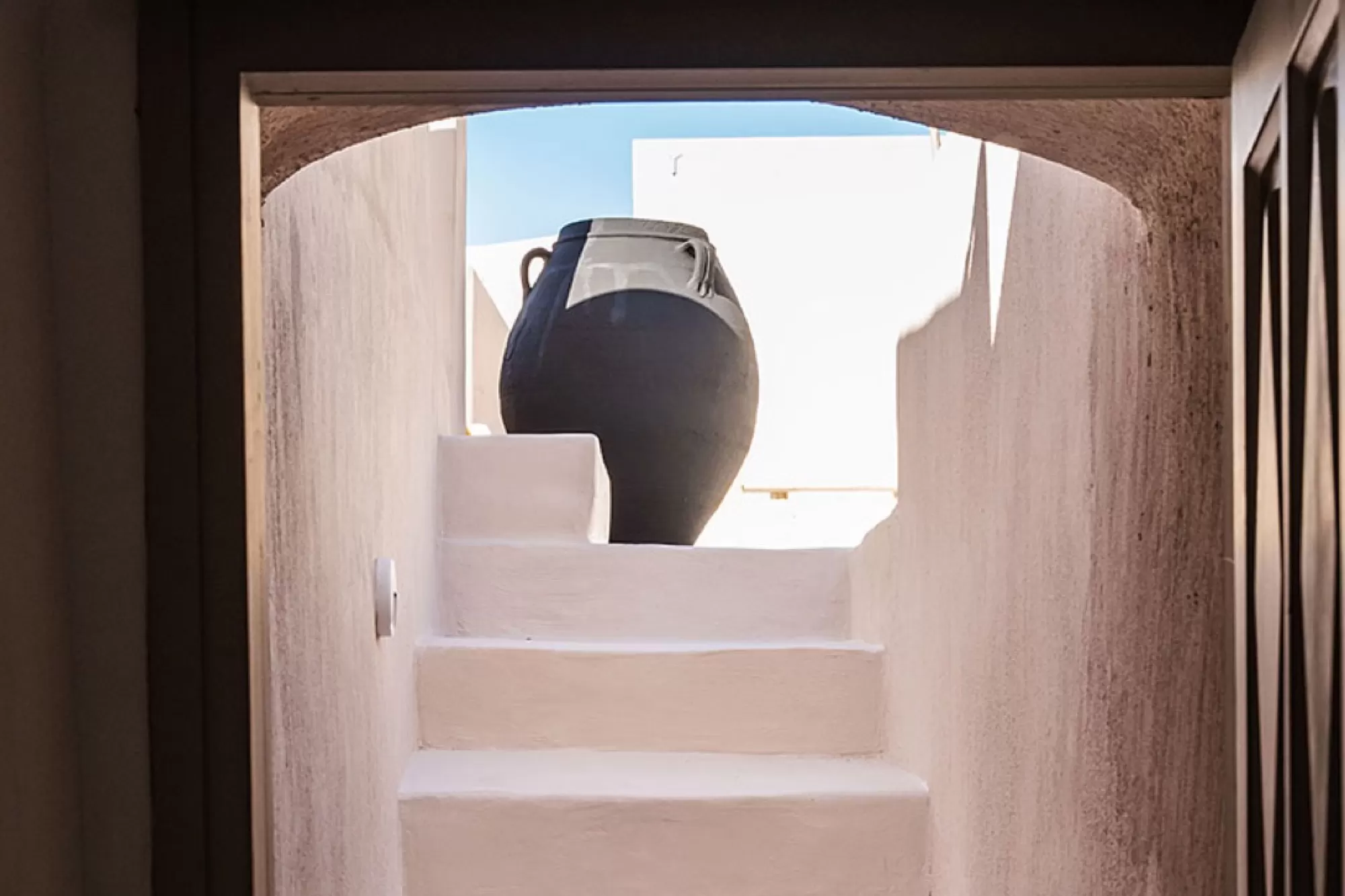Whitewashed steps and an amphora inside the castle of Pyrgos