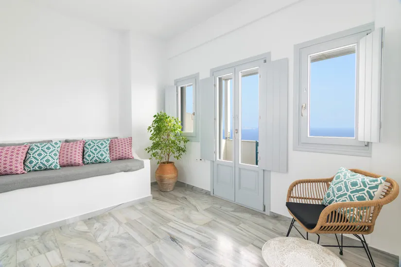 Cycladic suite interior with built-in sofa and sea-view windows