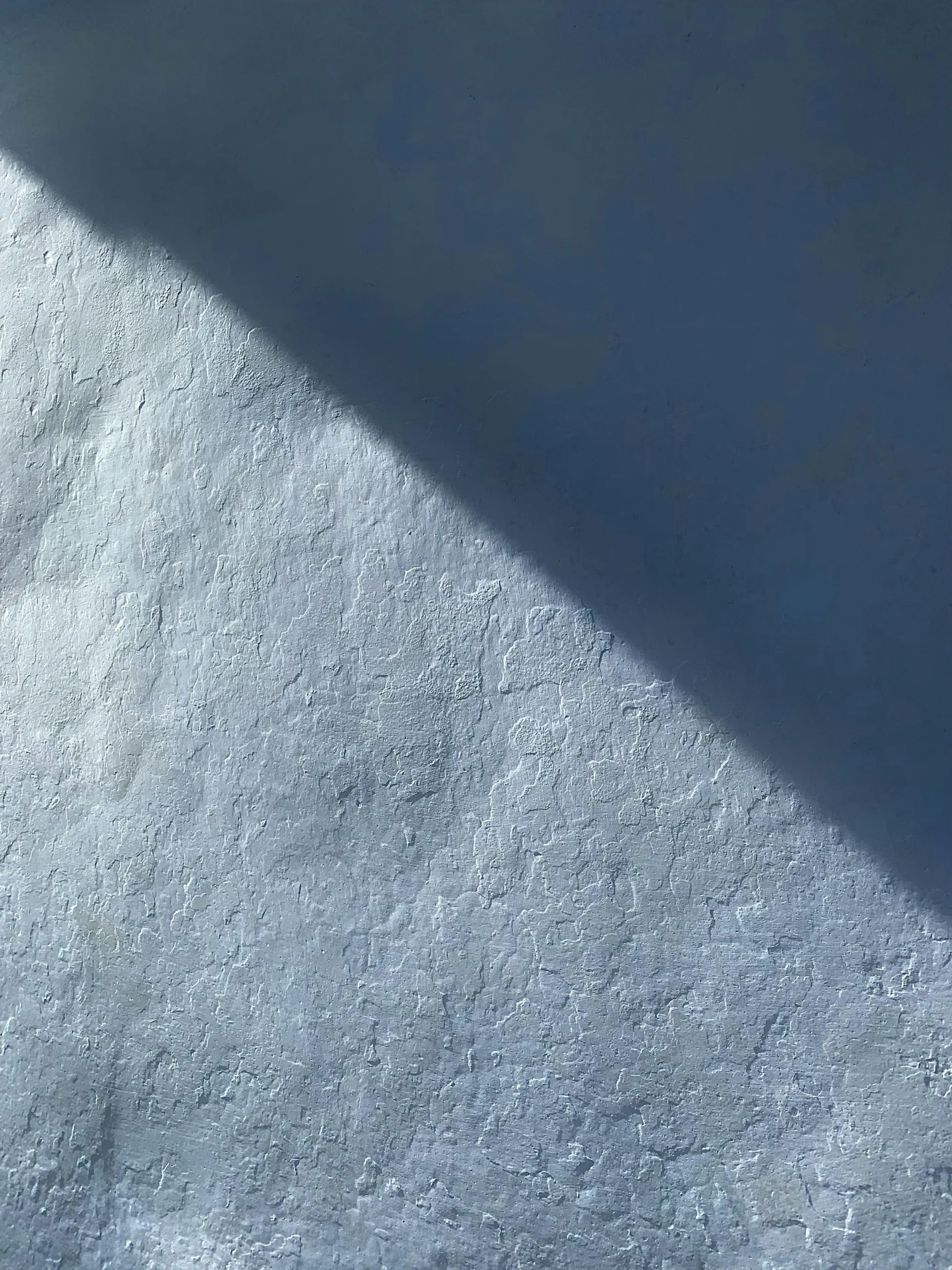 Shadow falling across a whitewashed wall
